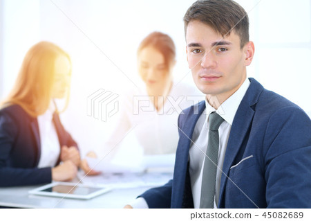 Group of business people or lawyers discussing terms of transaction in office. Focus at young Group of business people or lawyers discussing terms of transaction in office. Focus at young 45082689