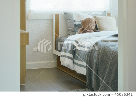 Child's bedroom with brown teddy bear on bed Child's bedroom with brown teddy bear on bed 45086341