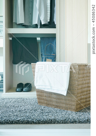 White towel on cloths basket with men's wardrobe White towel on cloths basket with men's wardrobe 45086342