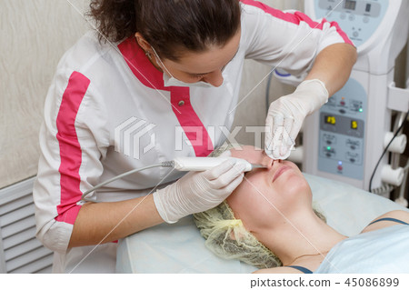 Cleaning face with ultrasonic scrubber 45086899