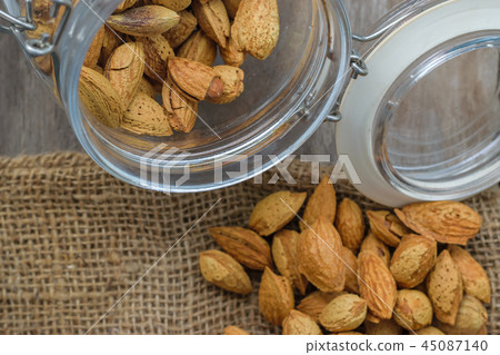 Almonds in the jar on natural sack Almonds in the jar on natural sack 45087140