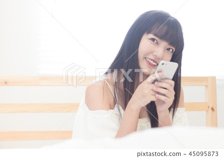 在床上使用手機的美女 在床上使用手機的美女 45095873