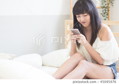 在床上使用手機的美女 在床上使用手機的美女 45095876