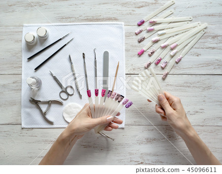 Nail art samples in female hands. Top view. Nail art samples in female hands. Top view. 45096611
