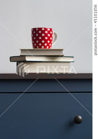 books with tea cup on top on blue chest 45101856