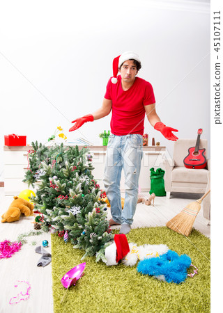 Man cleaning his apartment after christmas party 45107111