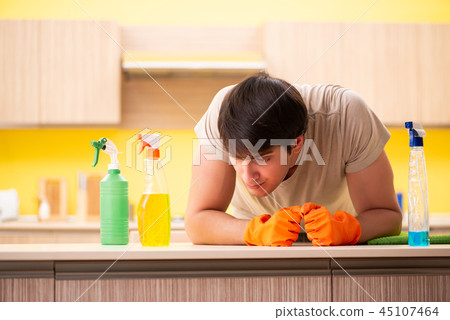 Single man cleaning kitchen at home 45107464