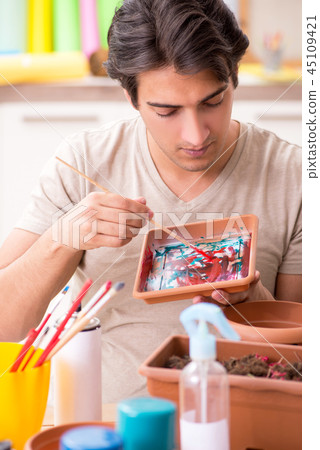 Young man decorating pottery in class 45109421