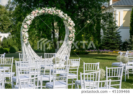 Summer outdoor wedding ceremony decoration. Beautiful white arch of branches and bouquet of white 45109466