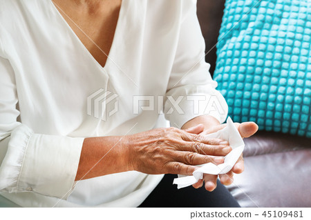 old woman clean hand with white soft tissue paper 45109481