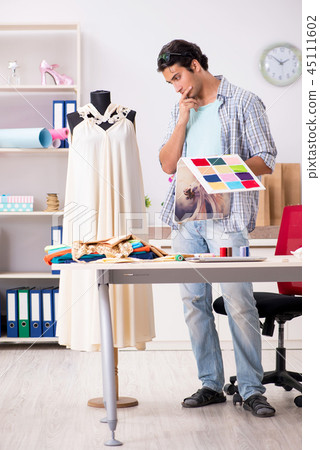 Young handsome tailor working in his workshop Young handsome tailor working in his workshop 45111602