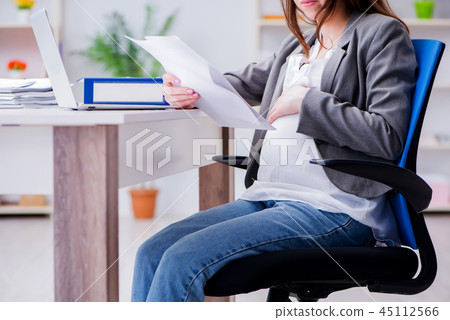 Pregnant woman struggling with pain in office Pregnant woman struggling with pain in office 45112566