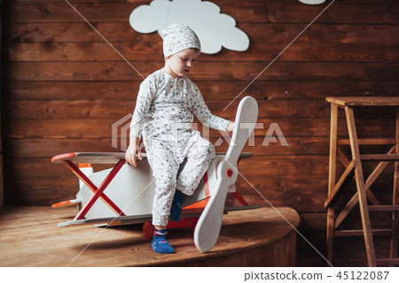 kid playing with wooden airplane 45122087
