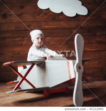 kid playing with wooden airplane 45122093
