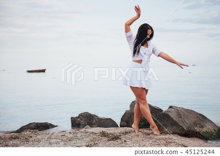 girl in frock dances barefoot on sand beach hands girl in frock dances barefoot on sand beach hands 45125244