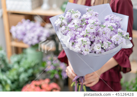 European floral shop. Two Bouquet of beautiful lilac flowers in woman hand. Excellent garden flowers 45126428