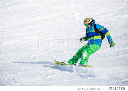 Photo of happy sports man snowboarding on snowy slope Photo of happy sports man snowboarding on snowy slope 45130389