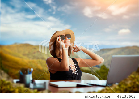 Woman at office table thinking about a travelling Woman at office table thinking about a travelling 45139602