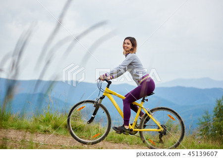 Young happy woman cycling on mountain bike at summer day Young happy woman cycling on mountain bike at summer day 45139607