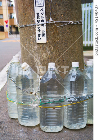 A pet bottle for dogs and cats that is placed on a telephone pole 45140437