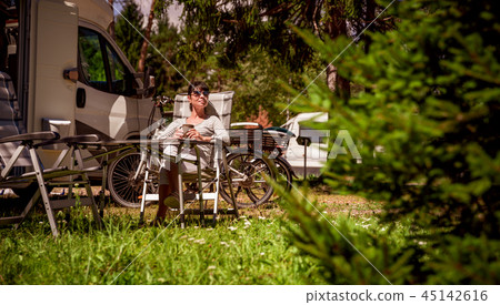 Woman with a mug of coffee near the camper. 45142616