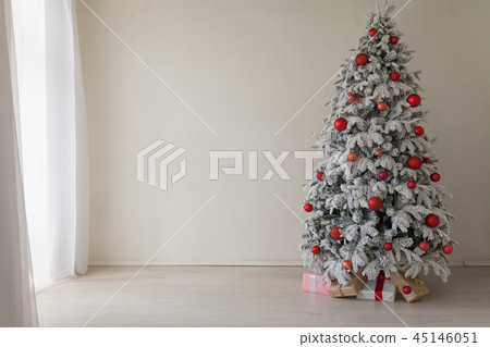 Christmas tree in a white room with gifts in the winter 45146051