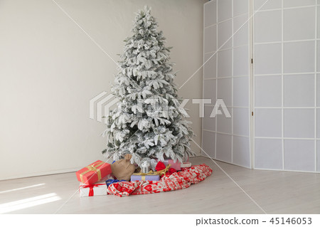 Christmas tree in a white room with gifts in the winter 45146053