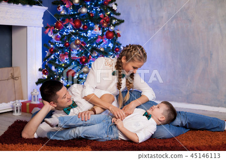 mom dad and a little boy open Christmas gifts for the new year 45146113