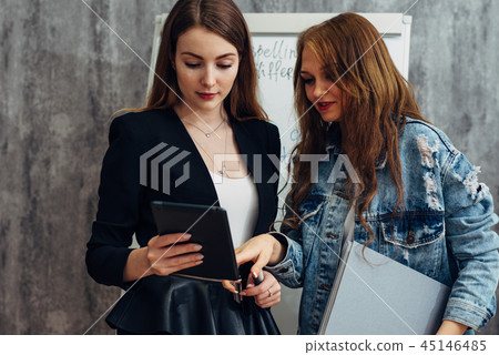 Student and teacher looking at gadget screen, using mobile app. 45146485
