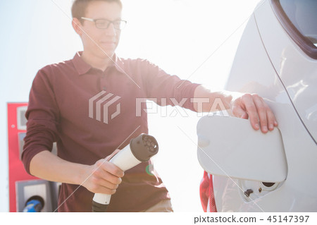 A man stands at the charging station A man stands at the charging station 45147397