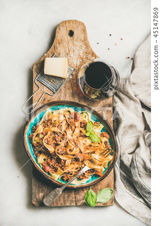 Tagliatelle bolognese with minced meat and glass of red wine 45147869