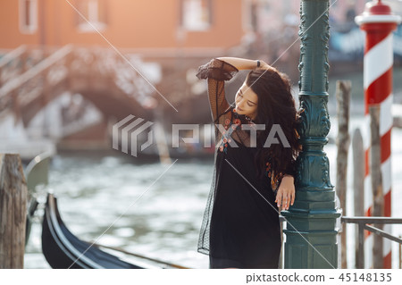 Travel tourist woman on pier against beautiful view on venetian chanal in Venice, Italy. 45148135