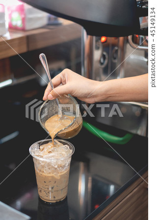 Barista pouring coffee to glass for iced coffee Barista pouring coffee to glass for iced coffee 45149134
