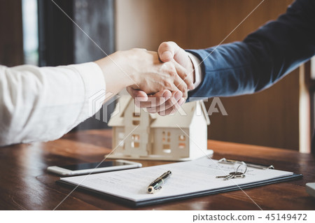 Real estate agent and customers shaking hands together celebrati Real estate agent and customers shaking hands together celebrati 45149472