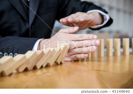 Wooden game strategy, Businessman hand stopping falling wooden d 45149640