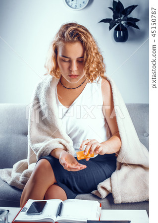 Attractive woman pours some pills onto her palm. 45150787