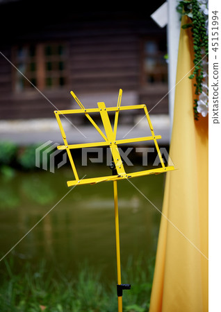 Arch for wedding ceremony in the open air, decorated with yellow fabric and flowers. Details close Arch for wedding ceremony in the open air, decorated with yellow fabric and flowers. Details close 45151994