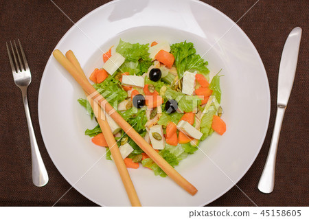 Salad of pumpkin, seeds, olives, on a white plate Salad of pumpkin, seeds, olives, on a white plate 45158605
