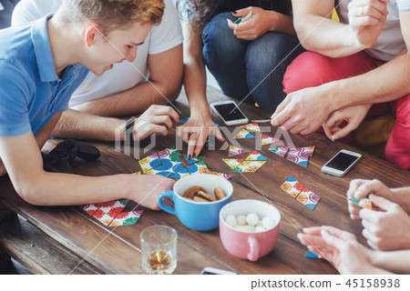 Top view creative photo of friends sitting at wooden table.  having fun while playing board game 45158938