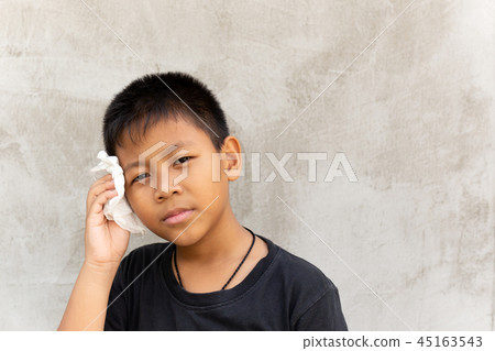 Asian boy wipe the sweat on his face with tissue. Asian boy wipe the sweat on his face with tissue. 45163543