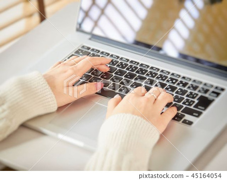 The hand of a woman who operates a computer in the living room 45164054