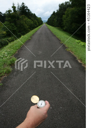A man's hand holding a compass 45164423