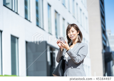 Office town Woman in suit with smartphone OL Business suit Portrait Recruit Office town Woman in suit with smartphone OL Business suit Portrait Recruit 45164497