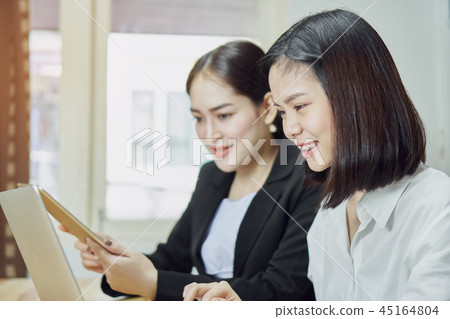 Business women are using laptops and smartphone. Business women are using laptops and smartphone. 45164804