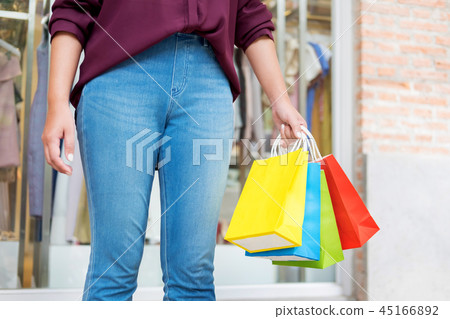 consumerism woman holding many shopping bags in fashion boutique 45166892