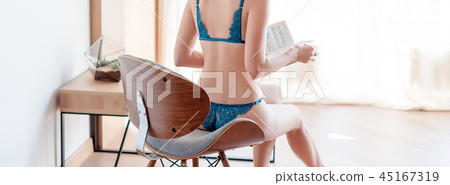 Sexy fashion model girl reading a book indoors. Beautiful lady in elegant lace panties and bra Sexy fashion model girl reading a book indoors. Beautiful lady in elegant lace panties and bra 45167319