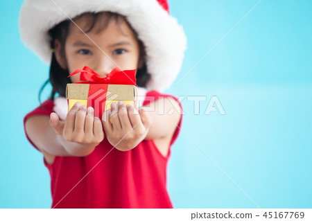Cute asian child girl holding beautiful gift Cute asian child girl holding beautiful gift 45167769
