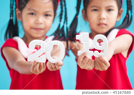 Two cute asian child girls holding numbers 2019 Two cute asian child girls holding numbers 2019 45167880
