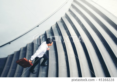 Successful businessman running fast upstairs 45168228