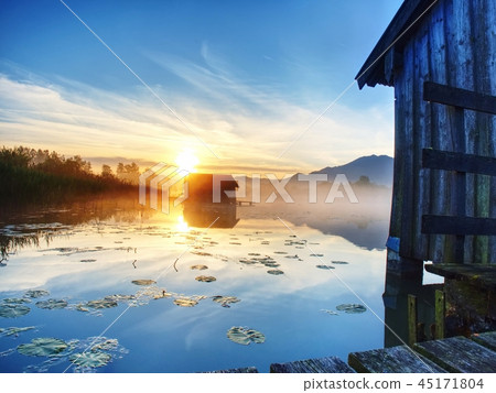 Morning at lake with traditional wooden boat house Morning at lake with traditional wooden boat house 45171804